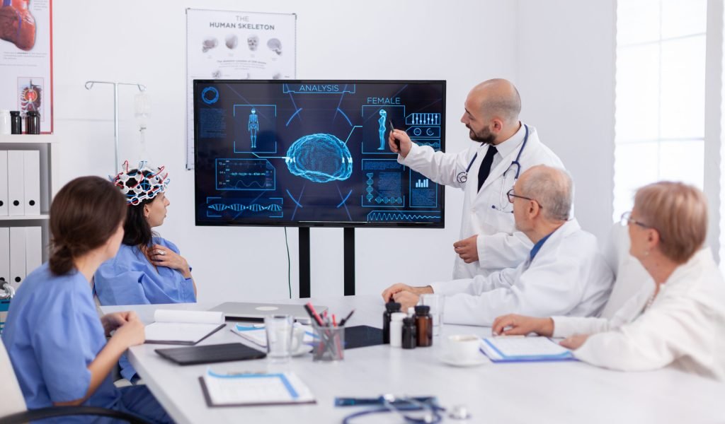 Physician pointing medical radiography to hospital coworkers analysing brain sickness presentation using high tech in meeting room. Hospital team monitoring ill treatment for healthcare expertise